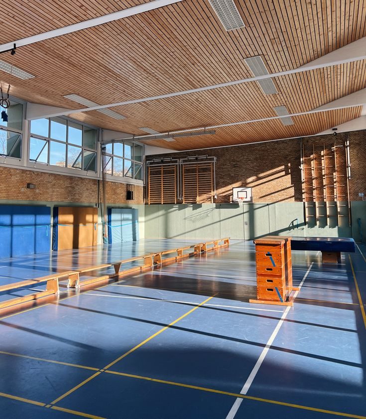 Solljus över idrottshallens golv före lektionen